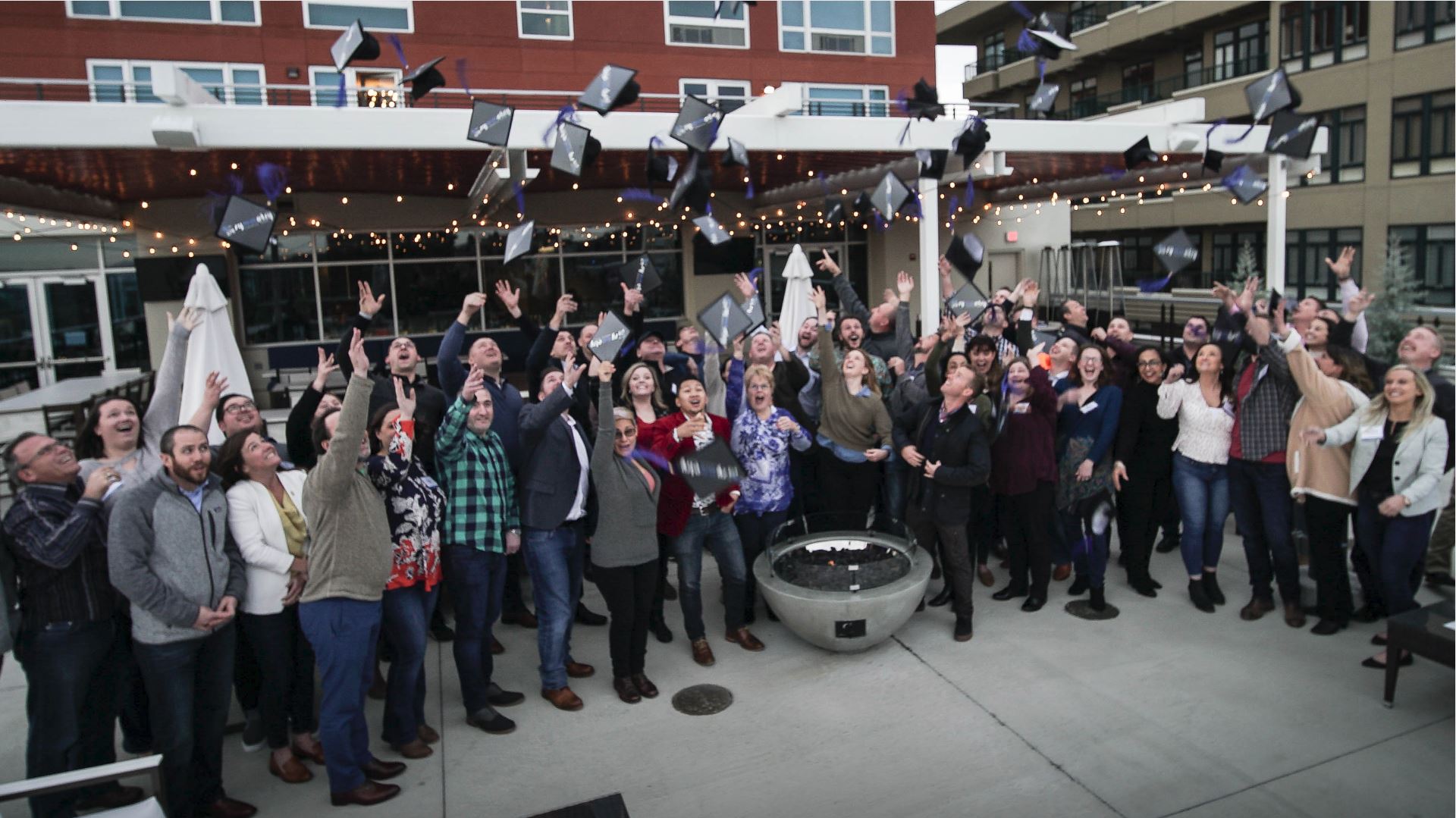 Graduates from Symmetry Financial Group's Agency Owners Academy throwing their caps into the air in Asheville, North Carolina