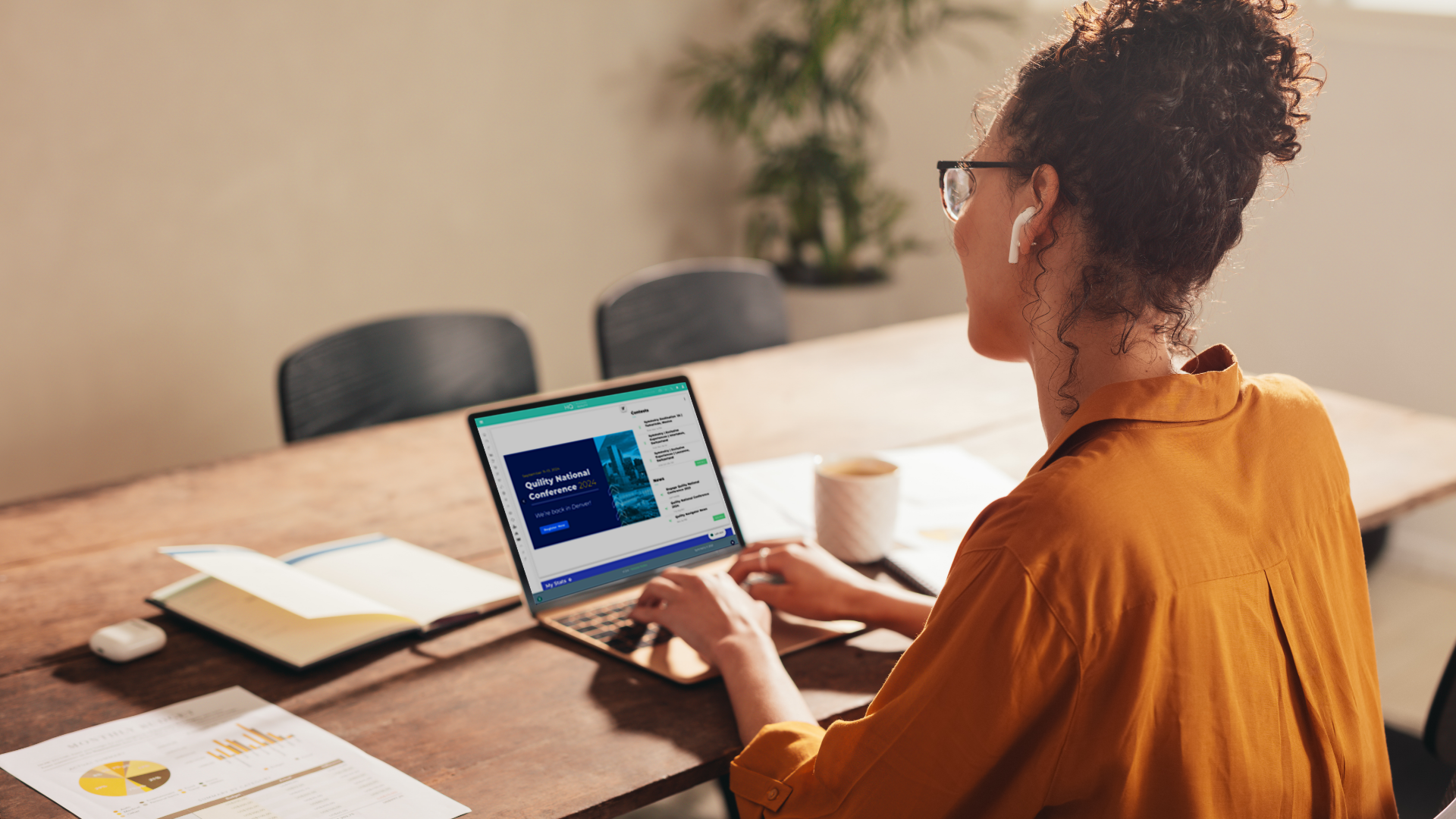 A woman working remotely on her laptop with the screen showing Quility HQ.