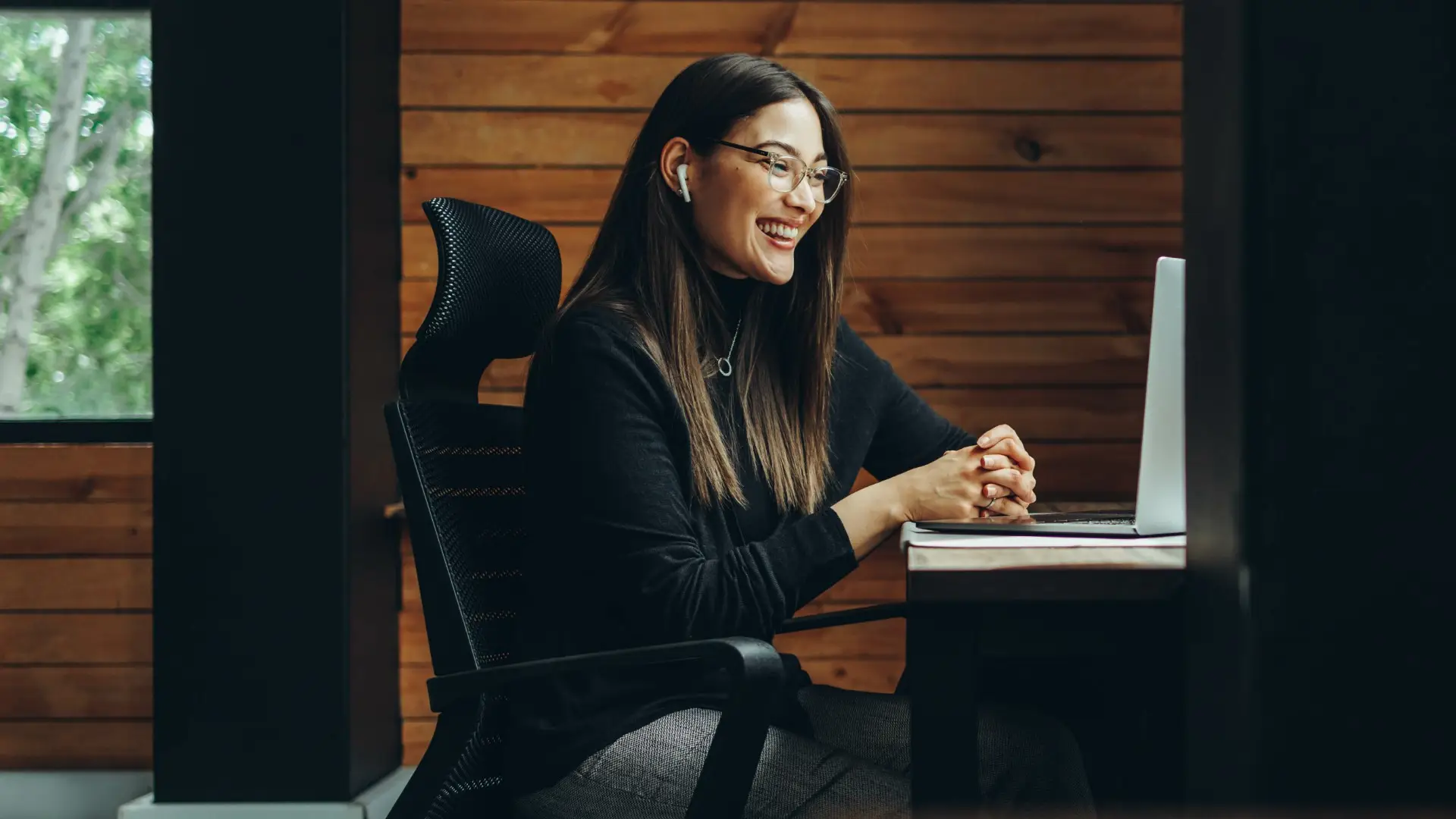 A woman working from a remote office, having a meeting with someone through a computer screen, someone we cannot see.