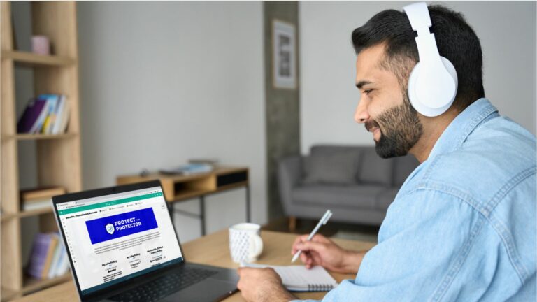 A man with headphones on working from his laptop which is opened to Quility HQ