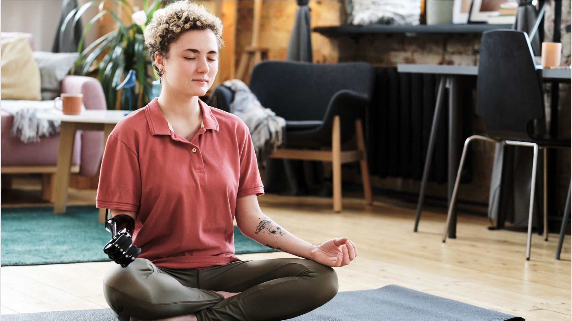 A woman with a prosthetic arm meditating at home