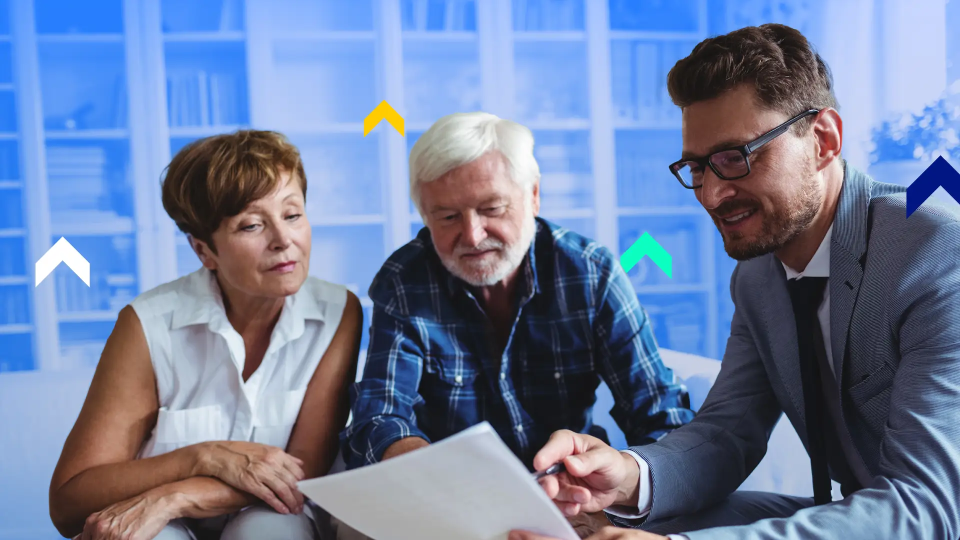 A life insurance agent going over some papers with two older clients at a table